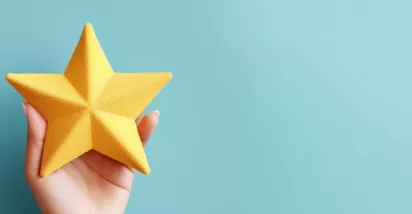 Image shows a hand holding a foam, yellow star.